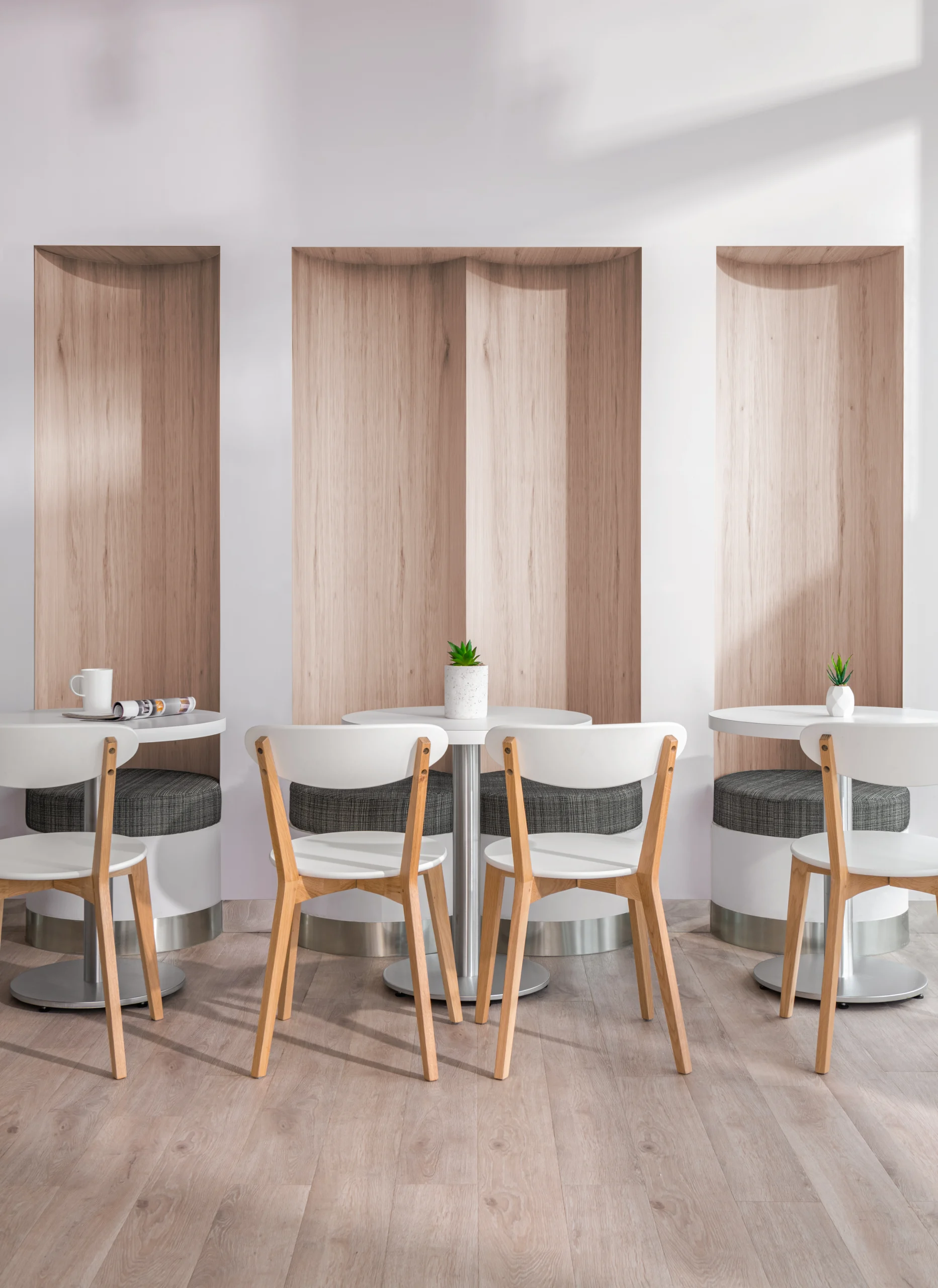 Interior Design - Interior view of a modern cafe featuring round tables and wooden chairs. Dexign Matter Studio