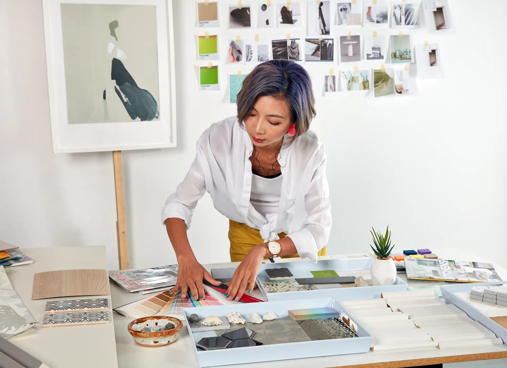 Interior Design - Interior designer arranging various material samples on a table in a studio setting. Dexign Matter Studio
