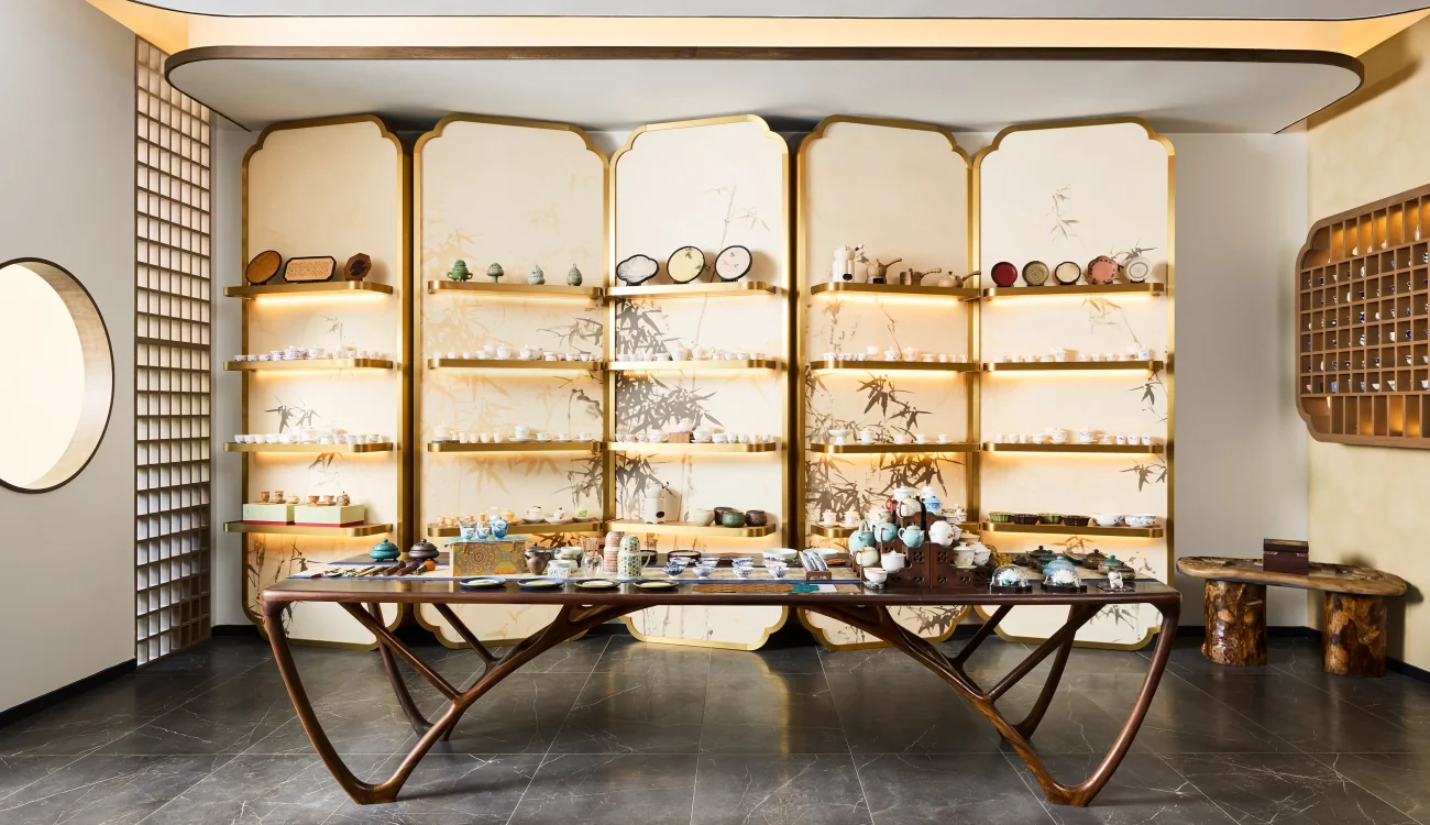 Interior Design - Interior view of a tea display featuring various tea products on shelves and a wooden table. Dexign Matter Studio