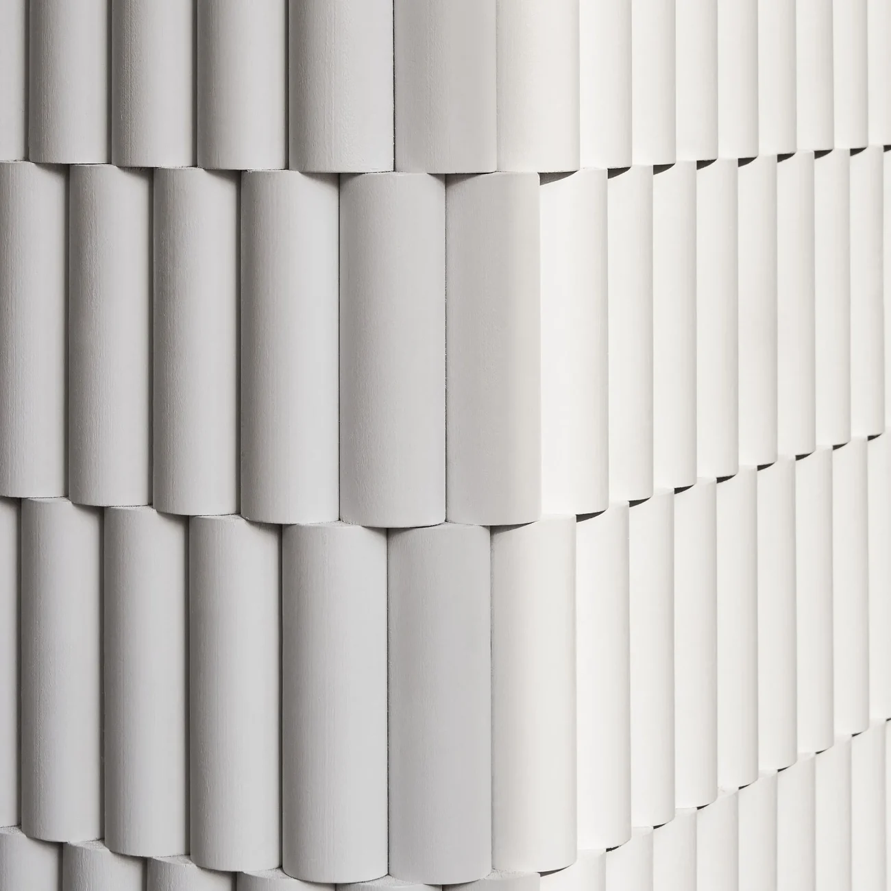 Interior Design - Close-up of textured wall paneling featuring neutral tones and a repetitive pattern. Dexign Matter Studio