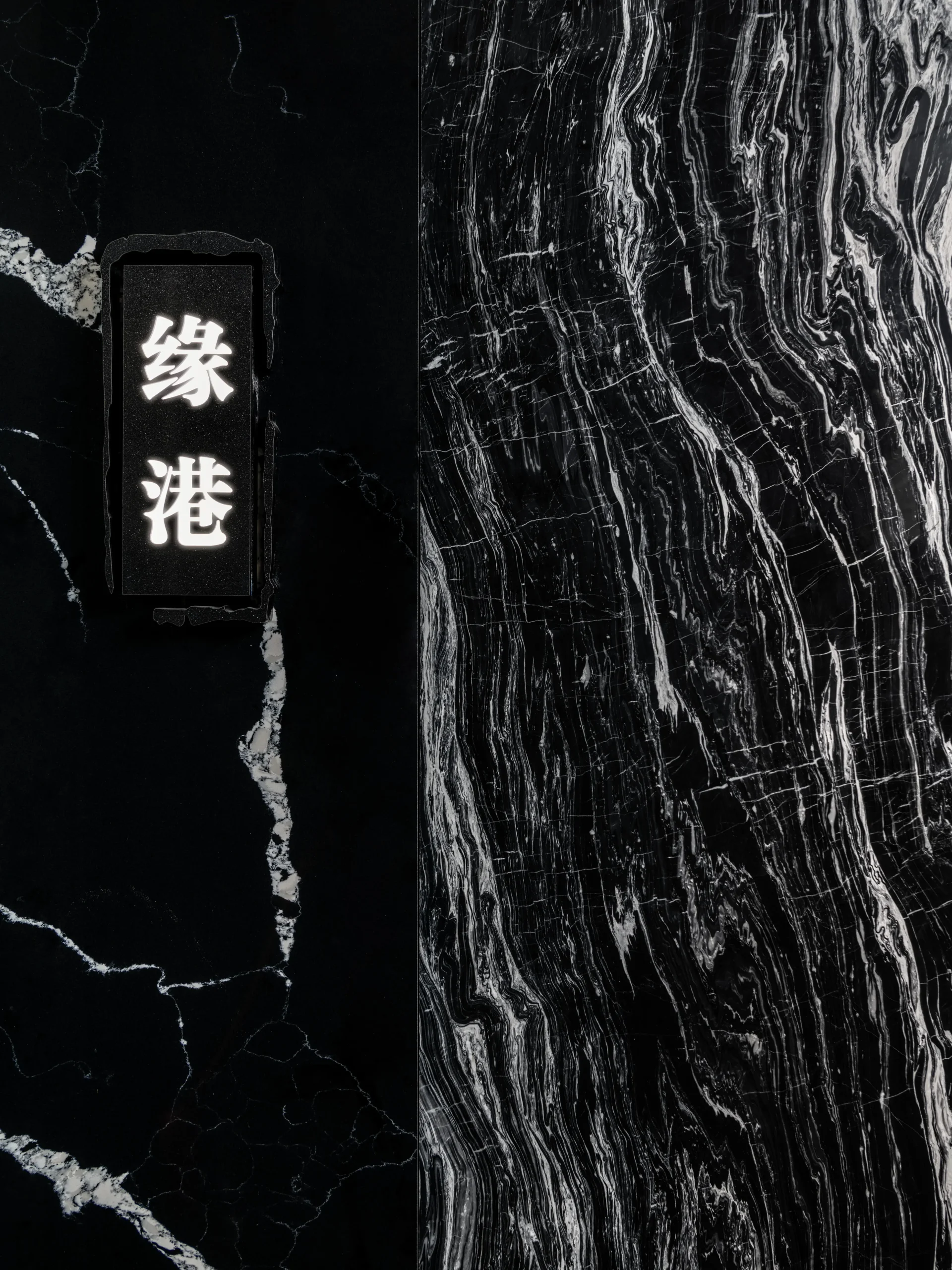 Interior Design - Black marble with white veining and a decorative plaque featuring Chinese characters. Dexign Matter Studio