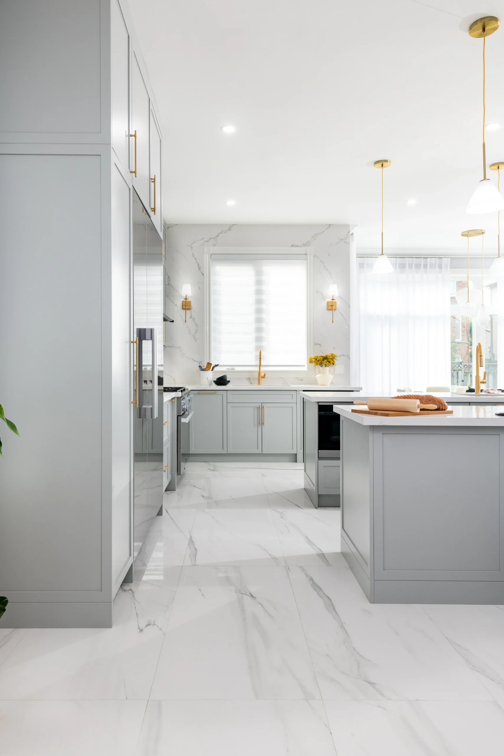 Interior Design - Modern kitchen featuring gray cabinets, marble countertops, and gold fixtures. Dexign Matter Studio